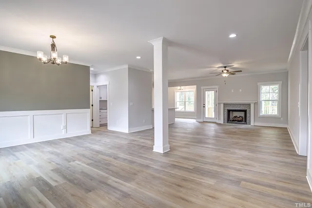 a view of an empty room with a fireplace and a window