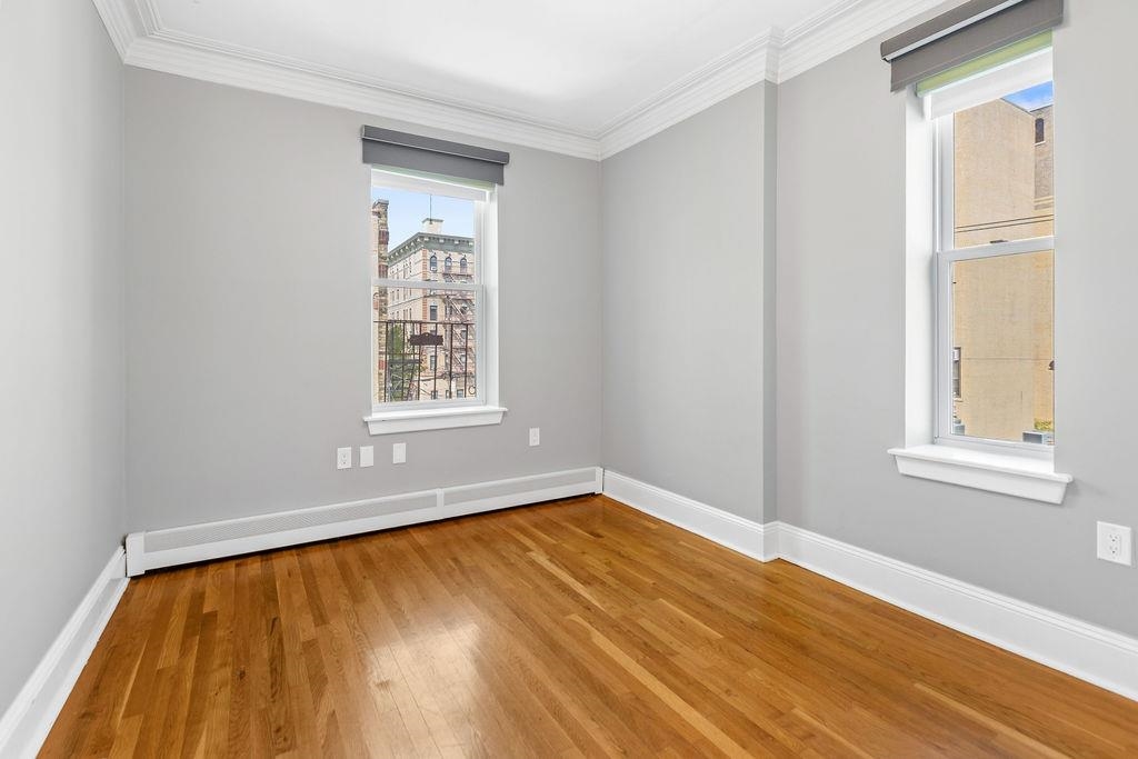 422 Grand Street, Unit 3 Hoboken, NJ 07030 - Photo 18 of 28 a view of an empty room with wooden floor and a window