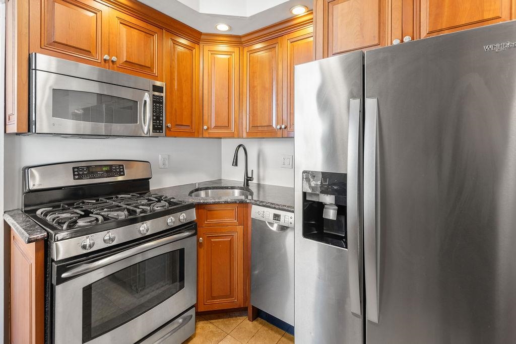 422 Grand Street, Unit 3 Hoboken, NJ 07030 - Photo 7 of 28 a kitchen with stainless steel appliances granite countertop a refrigerator stove and sink