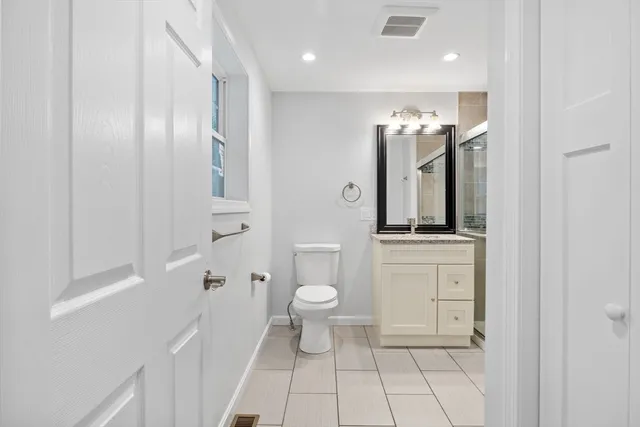 an empty room with wooden floor ceiling fan and windows