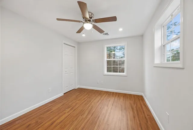 a view of empty room with wooden floor