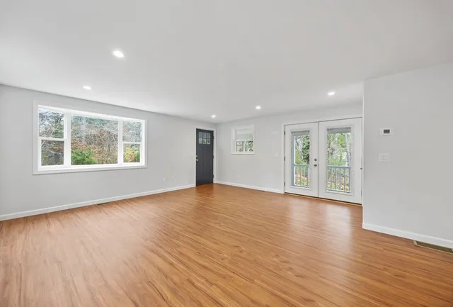 a view of a hallway with wooden floor and staircase