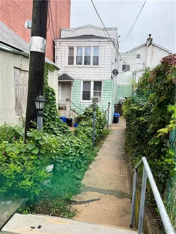 a front view of a house with a yard and potted plants