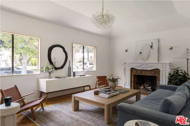 a living room with furniture a fireplace a window and a chandelier