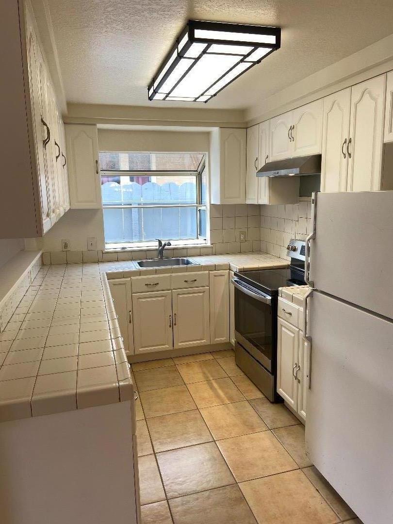 1693 Goodwin Street Seaside, CA 93955 - Photo 12 of 43 a kitchen with stainless steel appliances granite countertop a sink stove and refrigerator