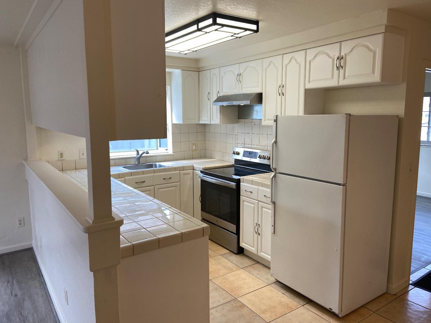 1693 Goodwin Street Seaside, CA 93955 - Photo 13 of 43 a kitchen with stainless steel appliances a refrigerator sink and cabinets