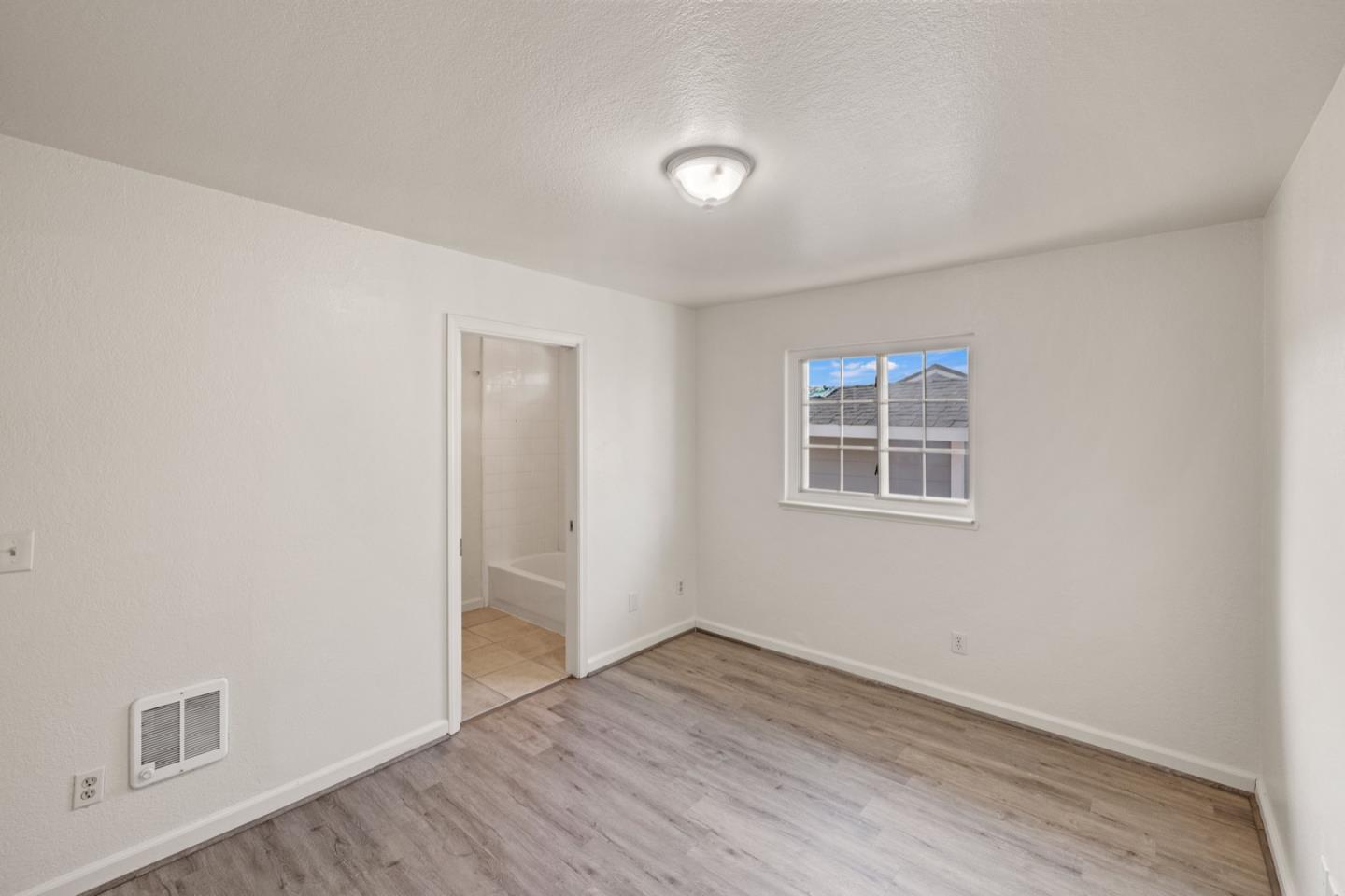 1693 Goodwin Street Seaside, CA 93955 - Photo 16 of 43 an empty room with wooden floor and windows