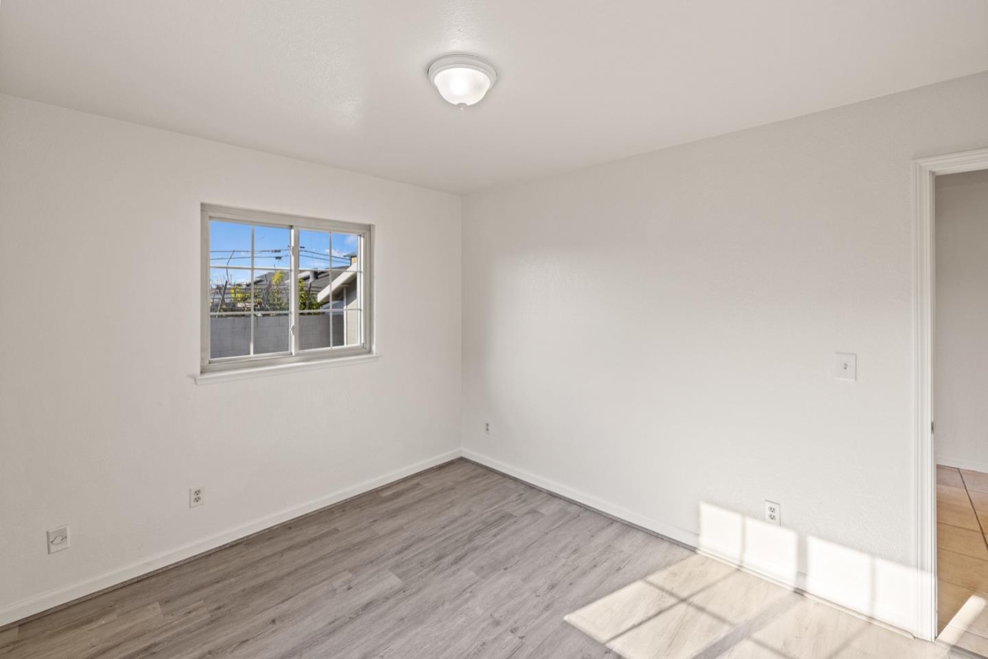 1693 Goodwin Street Seaside, CA 93955 - Photo 22 of 43 a room with a wooden floor and a window