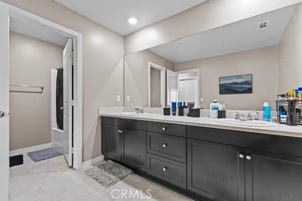 a en suite bathroom with a double vanity sink and a mirror