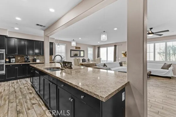 a large kitchen with granite countertop lots of counter top space and stainless steel appliances