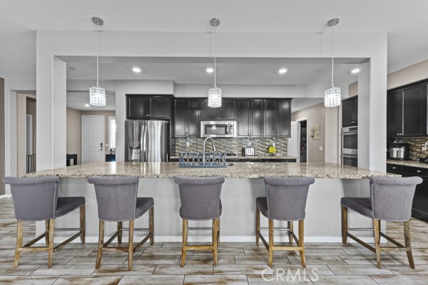 23347 Crystal Way Wildomar, CA 92595 - Photo 5 of 32 a kitchen with stainless steel appliances kitchen island granite countertop a dining table chairs and a refrigerator
