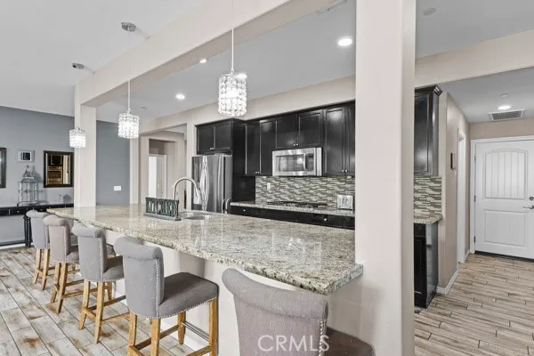 a view of a kitchen with granite countertop a large counter top stainless steel appliances and cabinets