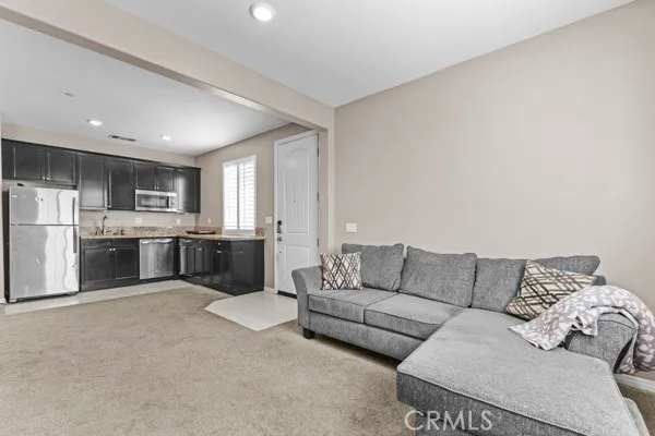 a living room with furniture and kitchen view