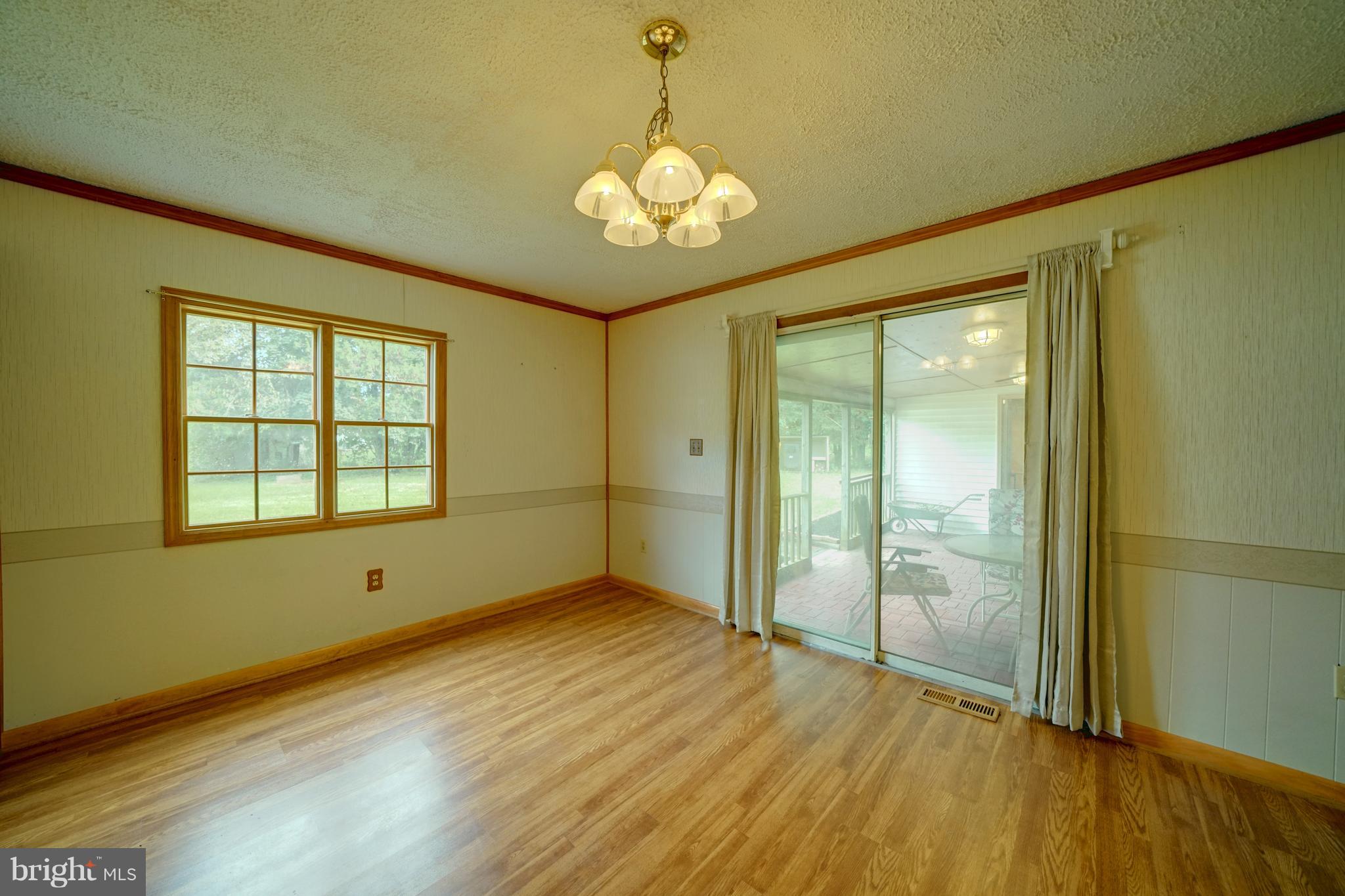 241 Burns Crossing Road Severn, MD 21144 - Photo 13 of 30 a view of an empty room with wooden floor and a window