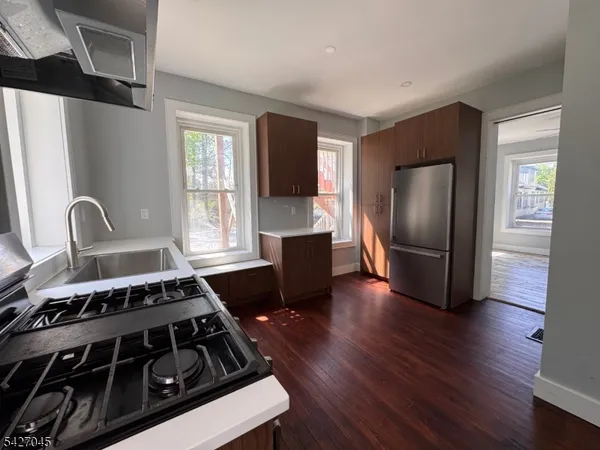 a kitchen with wooden floors a stove and a refrigerator