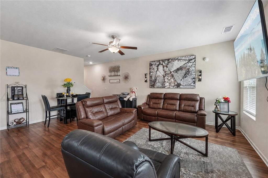 10933 Wheeler Trace Hampton, GA 30228 - Photo 8 of 22 a living room with furniture a couch and wooden floor