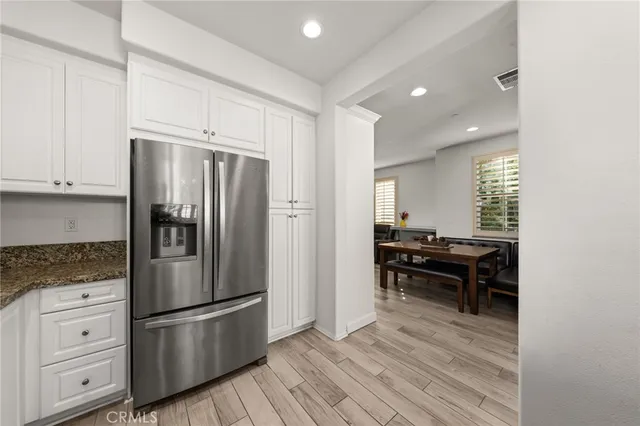 a kitchen with stainless steel appliances a refrigerator stove and wooden cabinets
