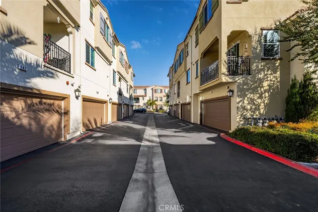 a view of a brick house with large trees and a small yard