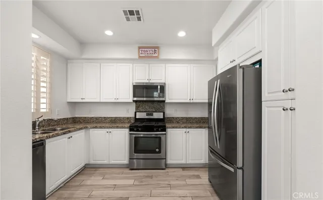 a kitchen with stainless steel appliances and refrigerator