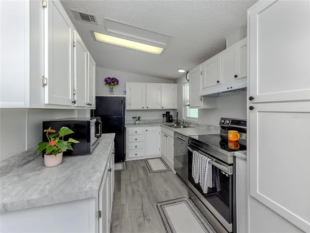 a kitchen with cabinets appliances and a window