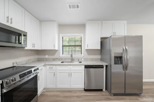 a kitchen with stainless steel appliances granite countertop a stove a refrigerator and a microwave