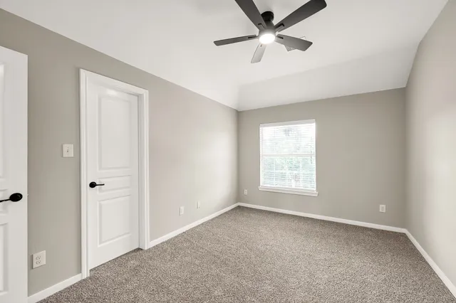 a view of empty room with ceiling fan
