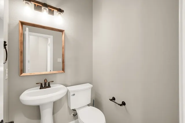a bathroom with a sink mirror and toilet