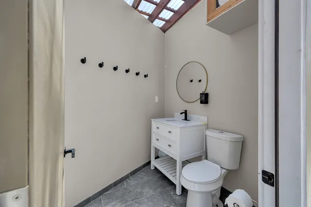a bathroom with a toilet sink and mirror