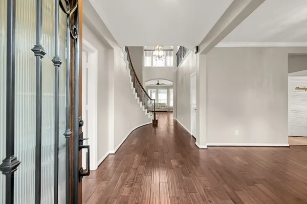 a view of a hallway with wooden floor and staircase