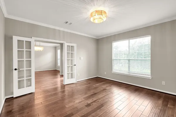 an empty room with wooden floor and window
