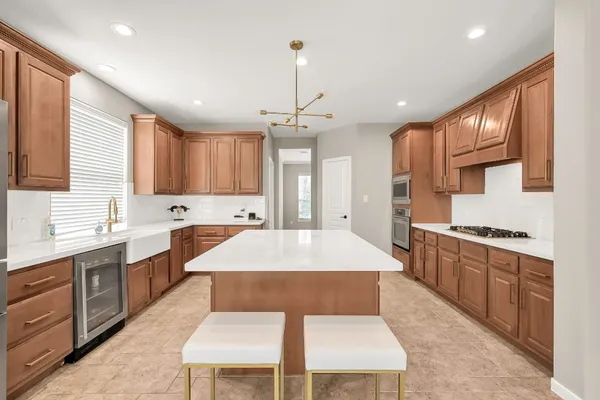 a large kitchen with stainless steel appliances kitchen island granite countertop a sink and cabinets