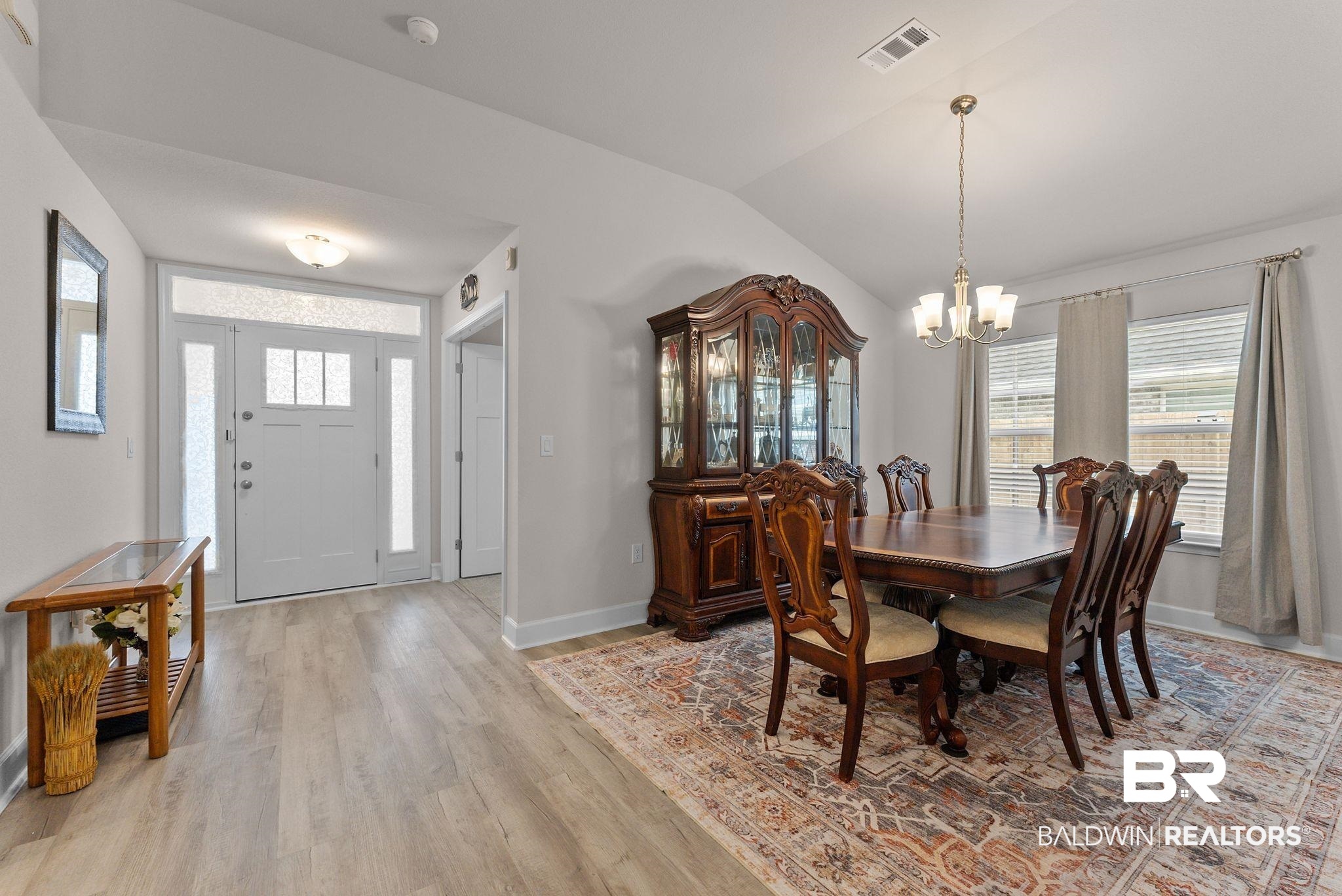 692 Mayflower Drive Foley, AL 36535 - Photo 6 of 40 Dining area with vaulted ceiling, light wood-type flooring, and a chandelier