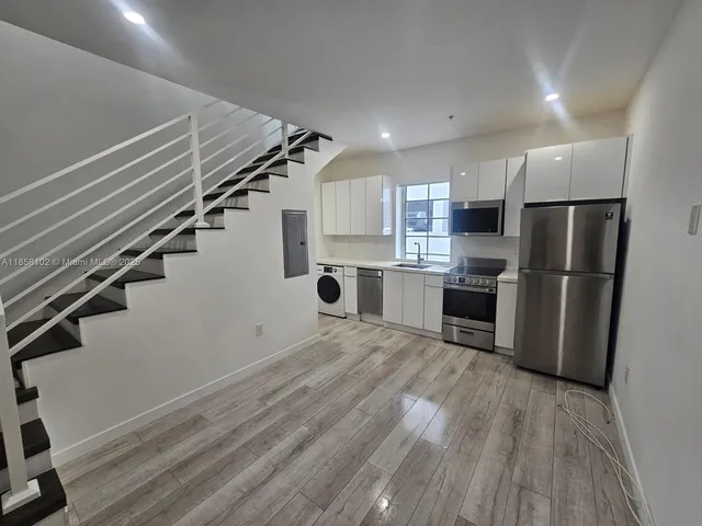 a kitchen with stainless steel appliances a refrigerator and a stove top oven