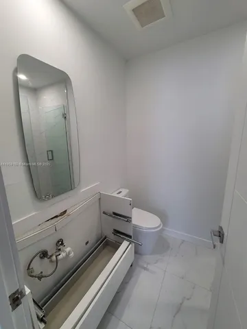 a bathroom with a toilet a sink and mirror