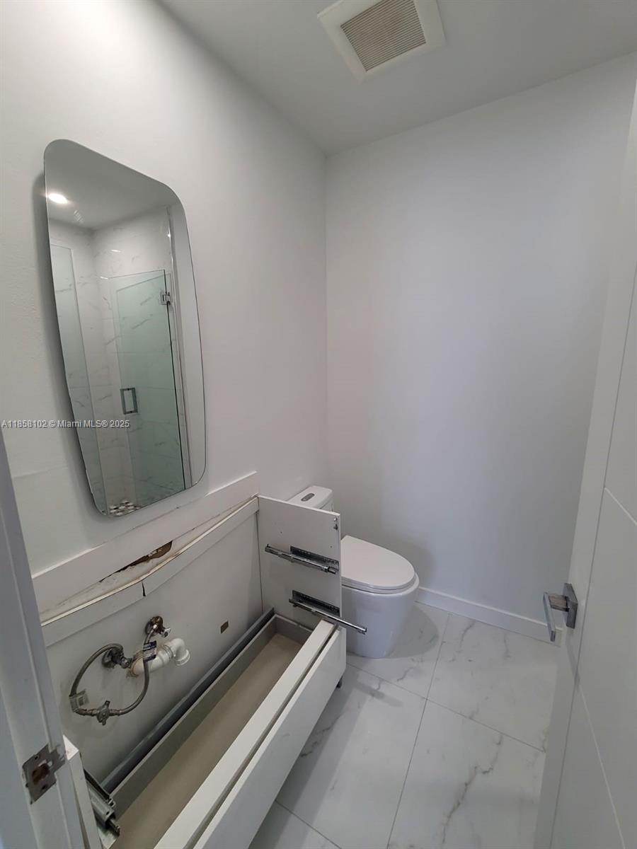 1610 Euclid Avenue, Unit A107 Miami Beach, FL 33139 - Photo 13 of 14 a bathroom with a toilet a sink and mirror