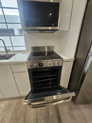 a stove top oven sitting inside of a kitchen