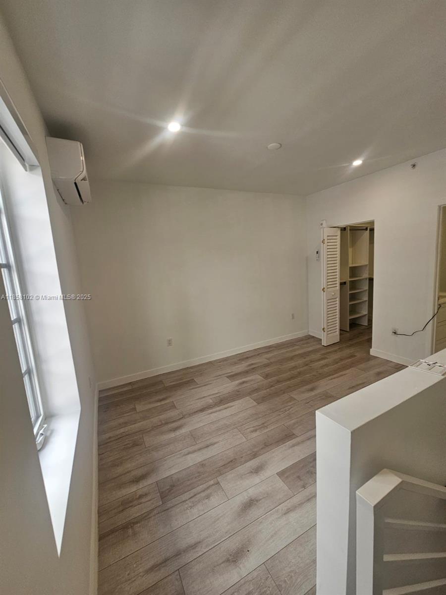 1610 Euclid Avenue, Unit A107 Miami Beach, FL 33139 - Photo 8 of 14 a view of an empty room with wooden floor and a window