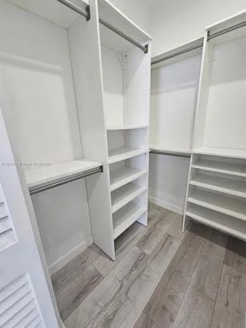 a view of walk in closet with empty racks