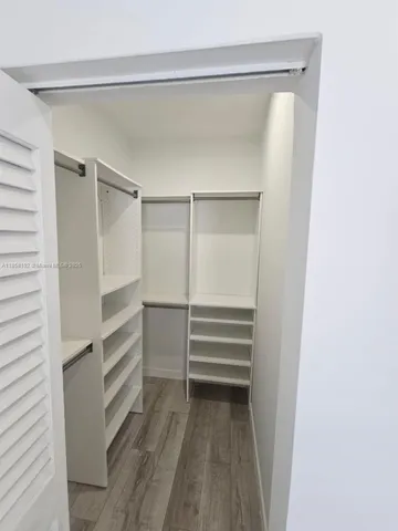a view of walk in closet with empty racks