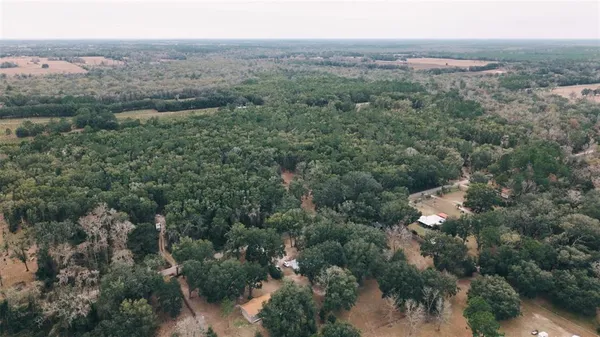 an aerial view of residential house with outdoor space and trees