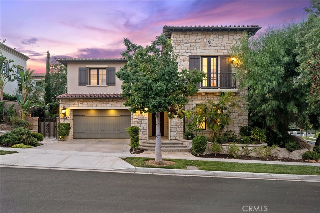 a front view of a house with a yard and trees