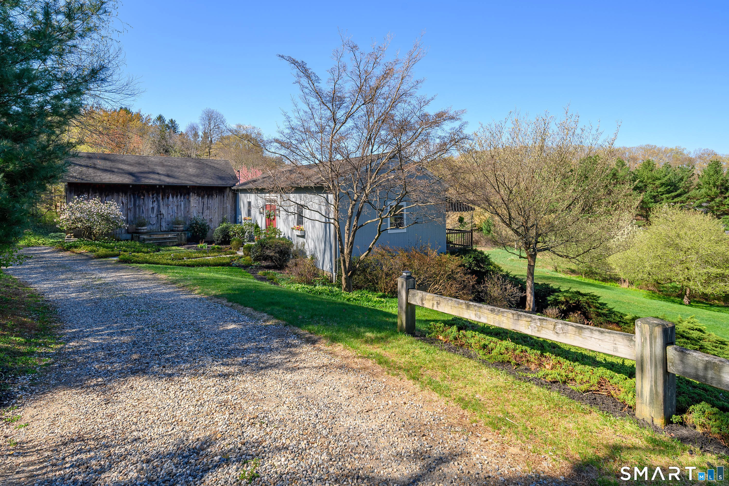 28 Poverty Hollow Road Newtown, CT 06470 - Photo 1 of 1 Long, private gravel driveway leading to home with mature landscaping and natural surroundings.