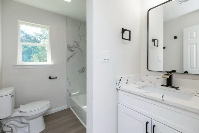 a bathroom with a sink a toilet and a mirror