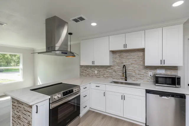 a kitchen with granite countertop a stove sink and cabinets