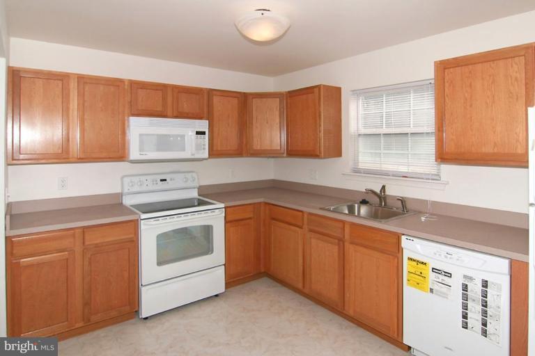 7204 Rutherford Green Circle Windsor Mill, MD 21244 - Photo 2 of 13 a kitchen with stainless steel appliances granite countertop a sink stove and cabinets