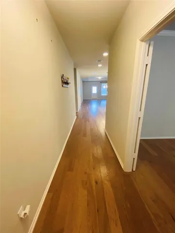 a view of a hallway with wooden floor