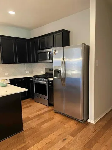 a kitchen with granite countertop a refrigerator and a sink