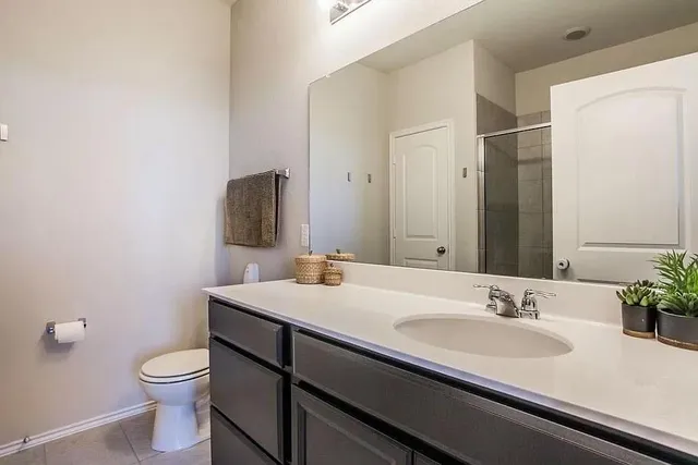 a bathroom with a sink a toilet and mirror