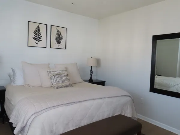 a bedroom with a bed and painting on the wall