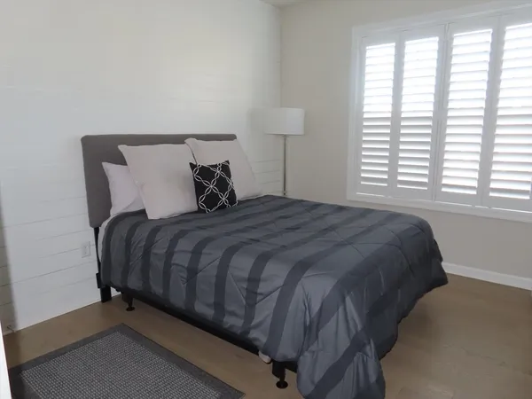 a large bed sitting in a bedroom next to a window